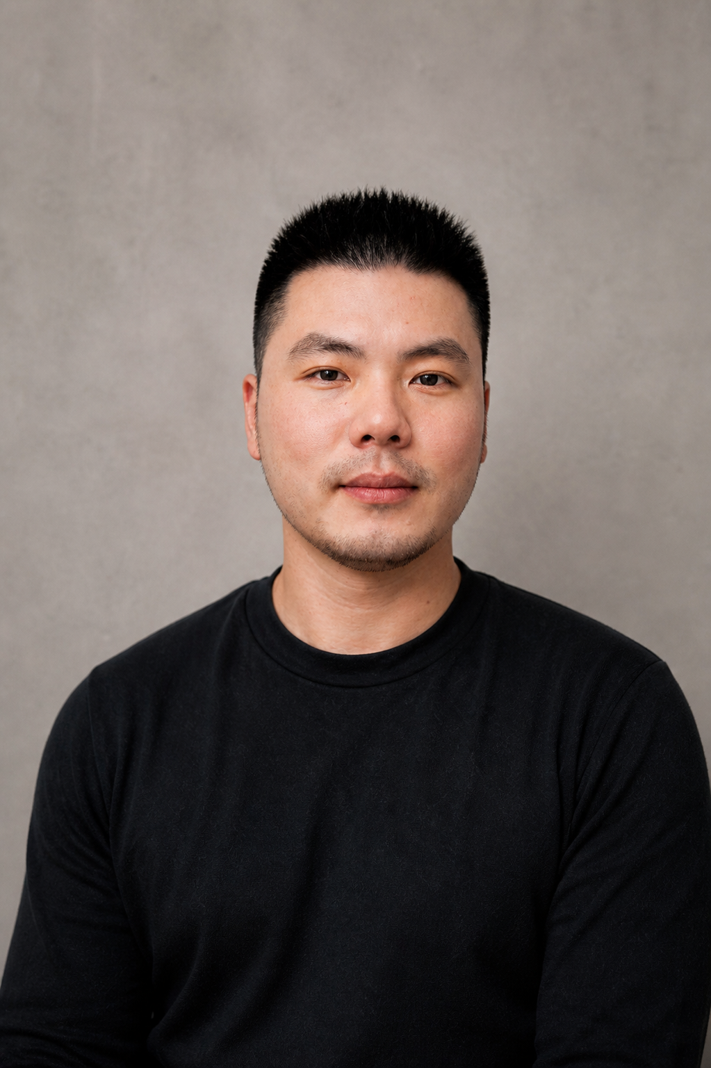 Monochrome portrait of a man with short hair wearing a black t-shirt.