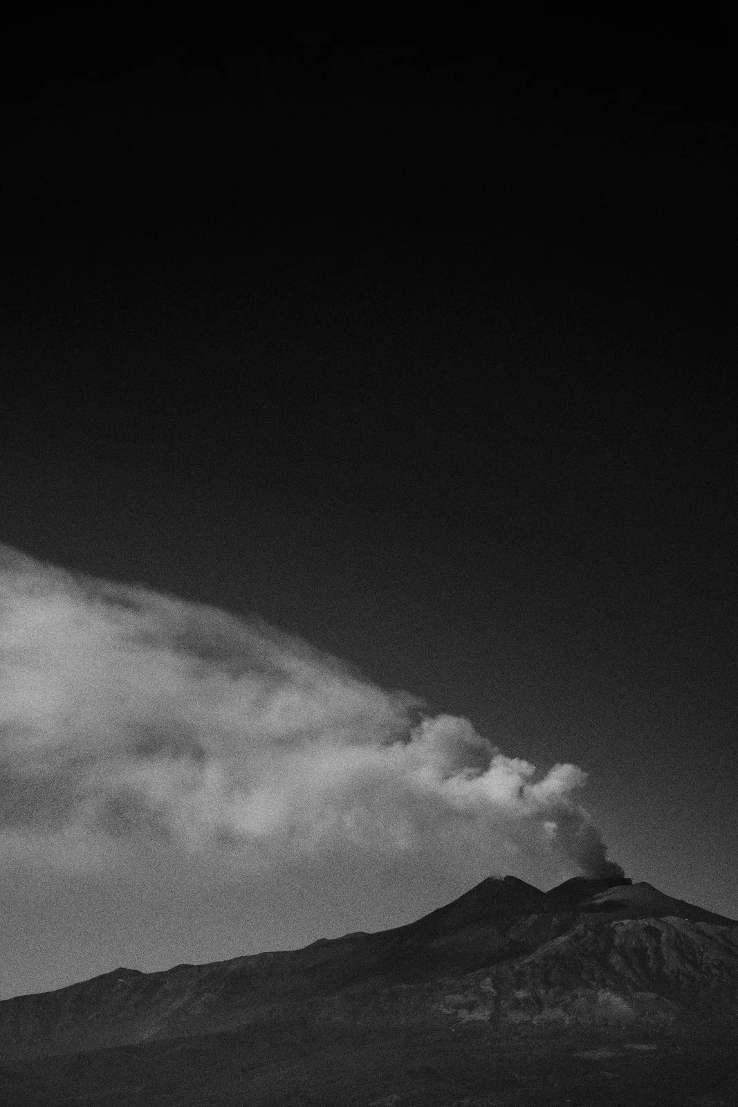 Ash plume streaming from the summit of Mount Etna against a dark sky, Sicily — Whispers of Form by Tom Imio