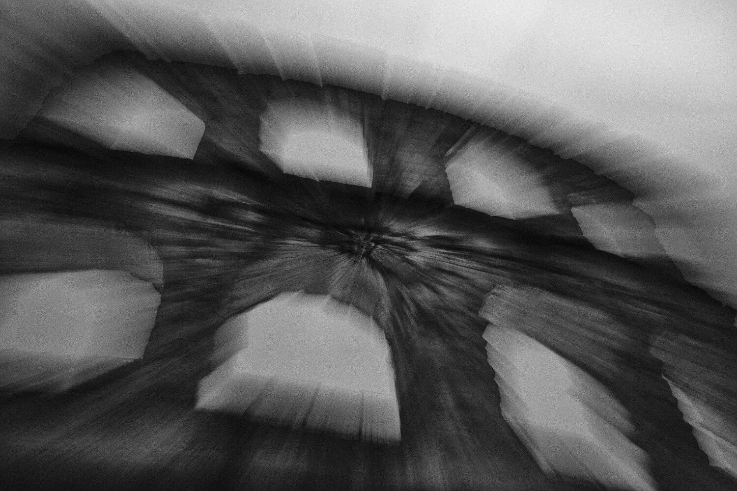 A black and white photo of tree rings from a cross-section of a tree trunk, showing concentric circles and radial lines.