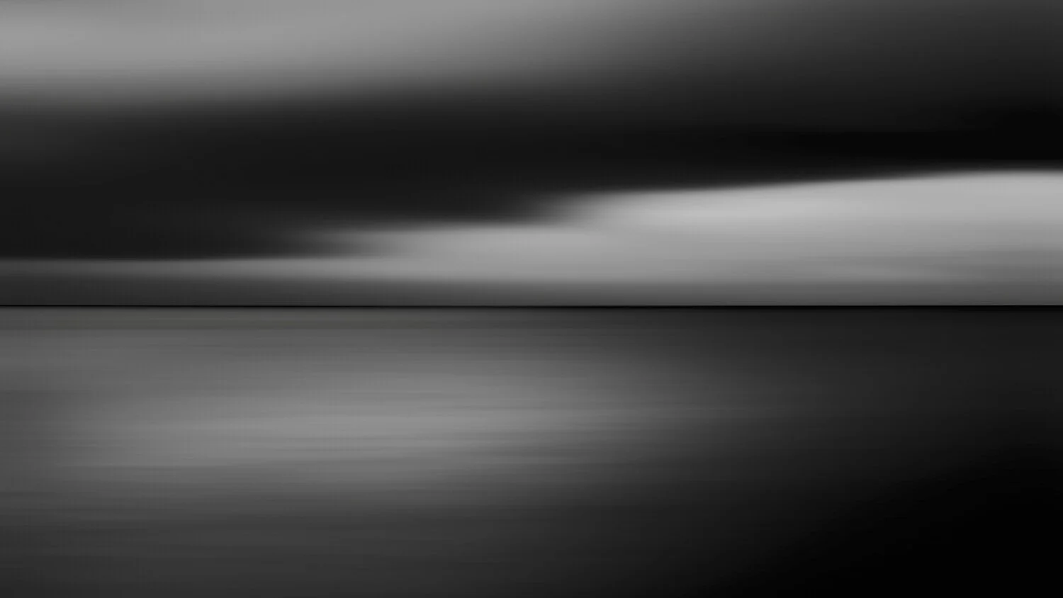 Abstract black and white blurred background with horizontal streaks.