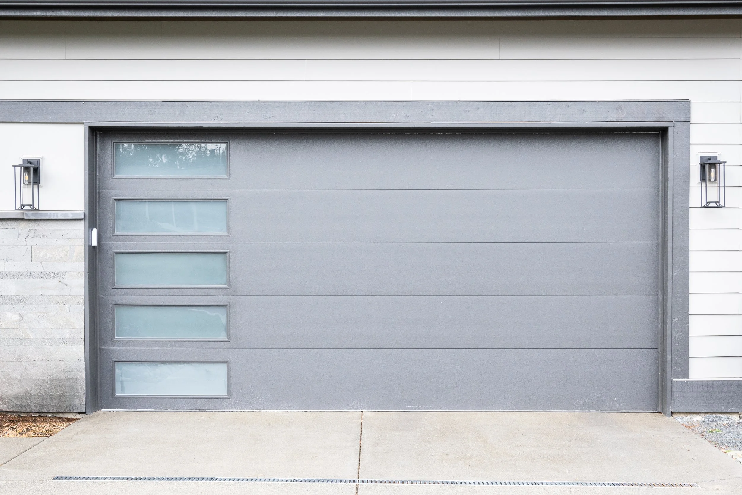 Gray modern garage door with vertical frosted glass windows