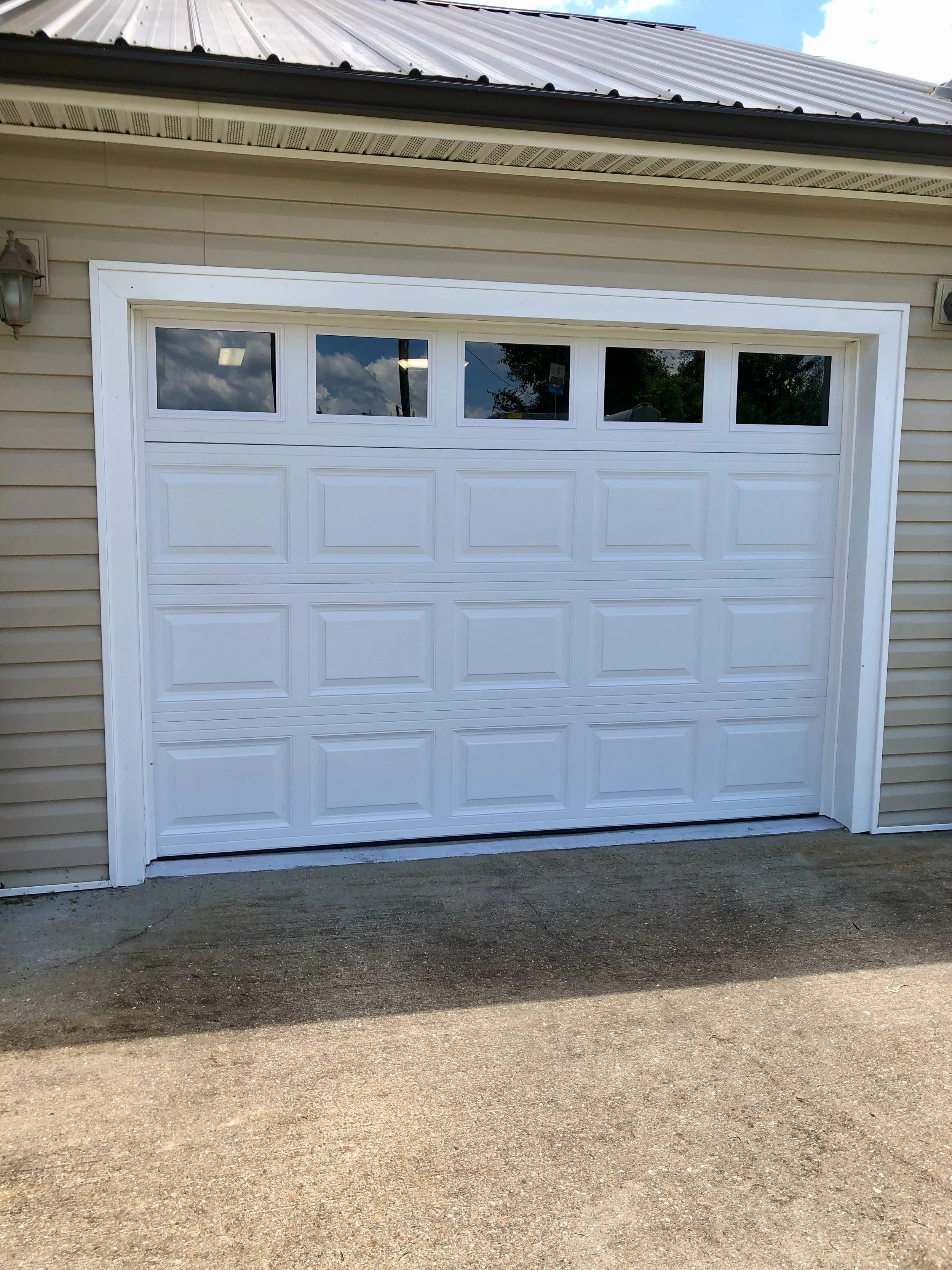 New White Residential Garage Door installation with windows at the top, completed by Elevate Garage Door Company in Mountain View, AR. A clean, modern upgrade that enhances curb appeal and functionality.