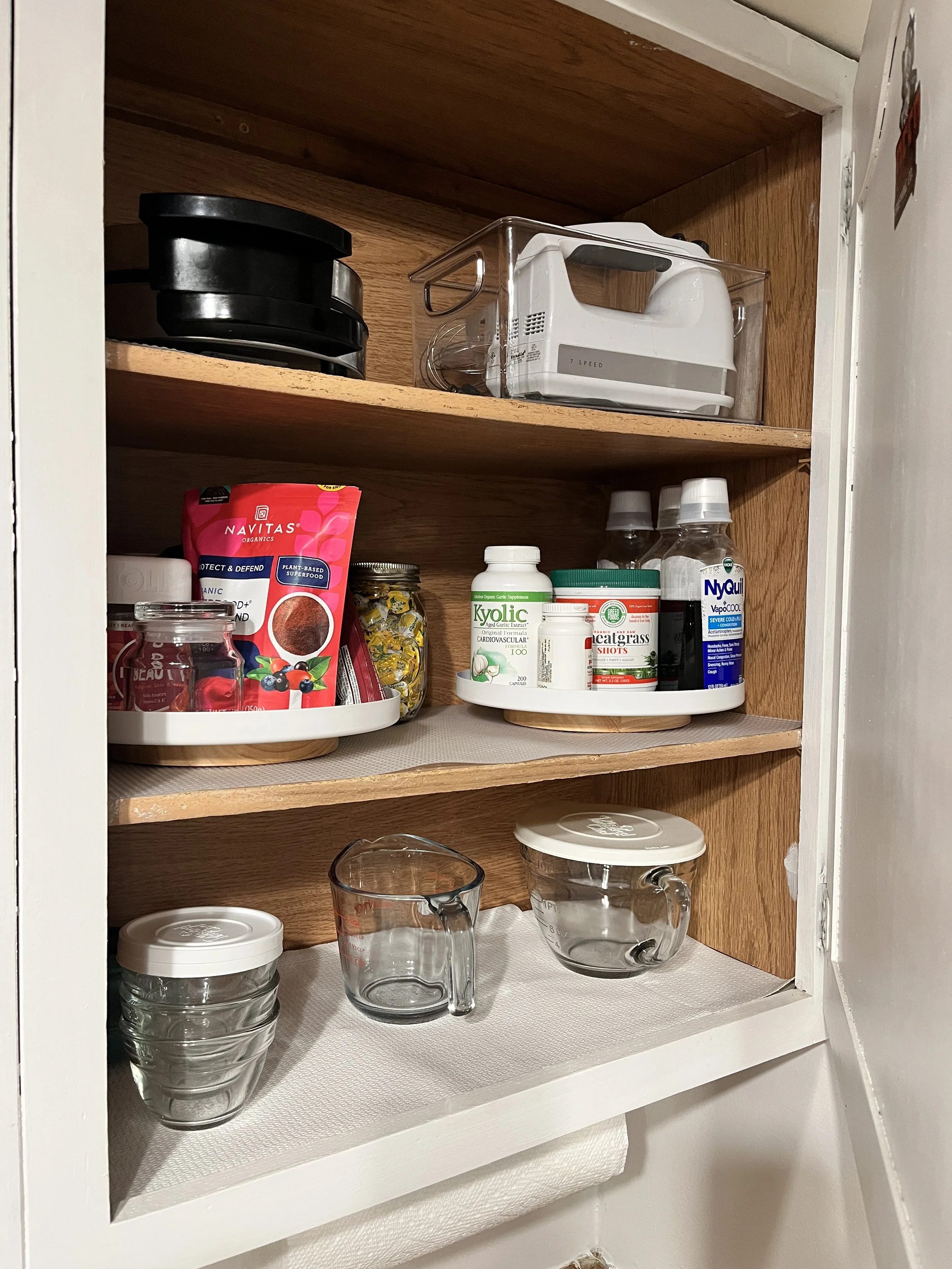 a peaceful home expert decluttering and organized kitchen storage of supplements and hand mixer