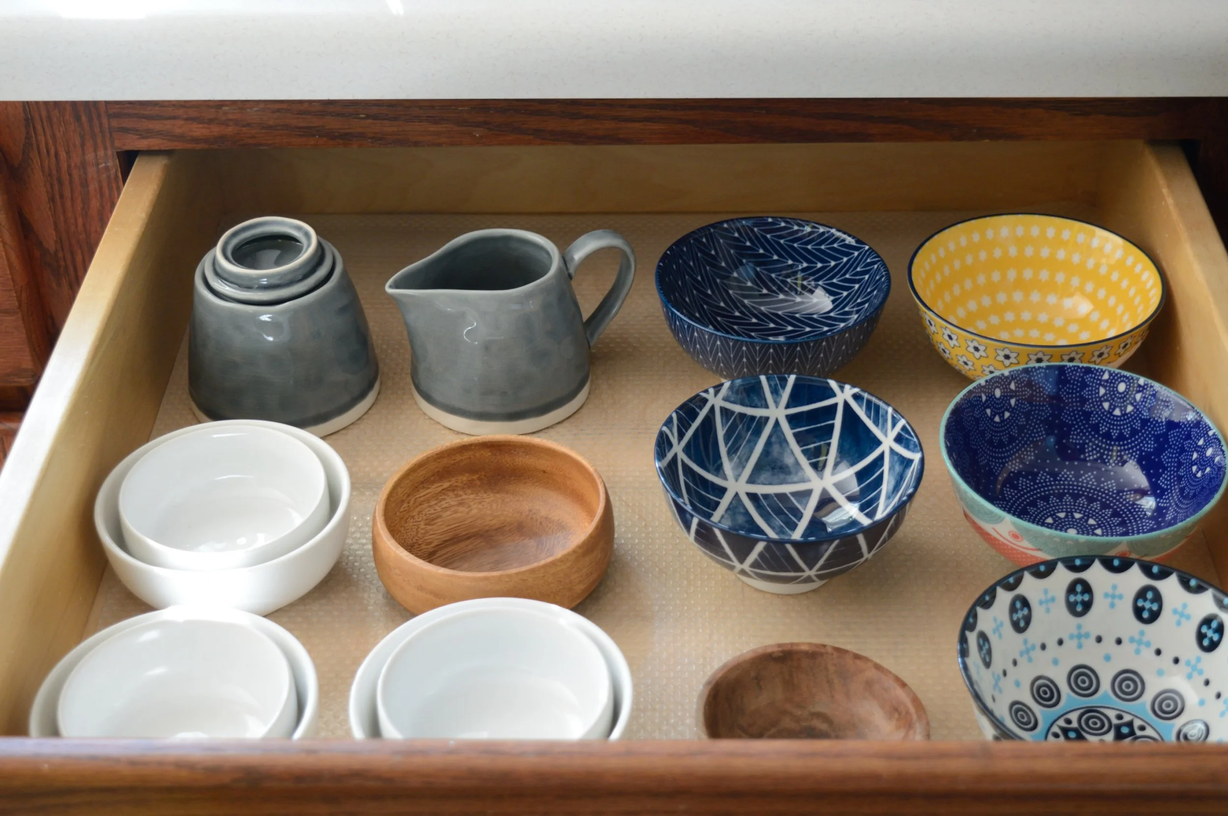 a peaceful home expert decluttering and organized kitchen storage of small bowls in drawer