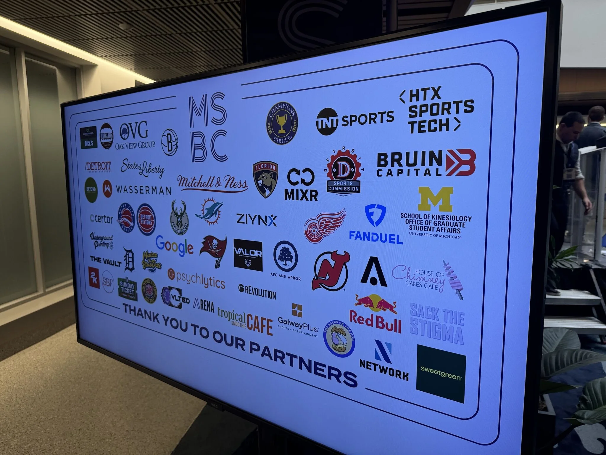 Digital display featuring logos of various sponsors and partners, including sports teams, companies, and organizations, with a message thanking the partners.