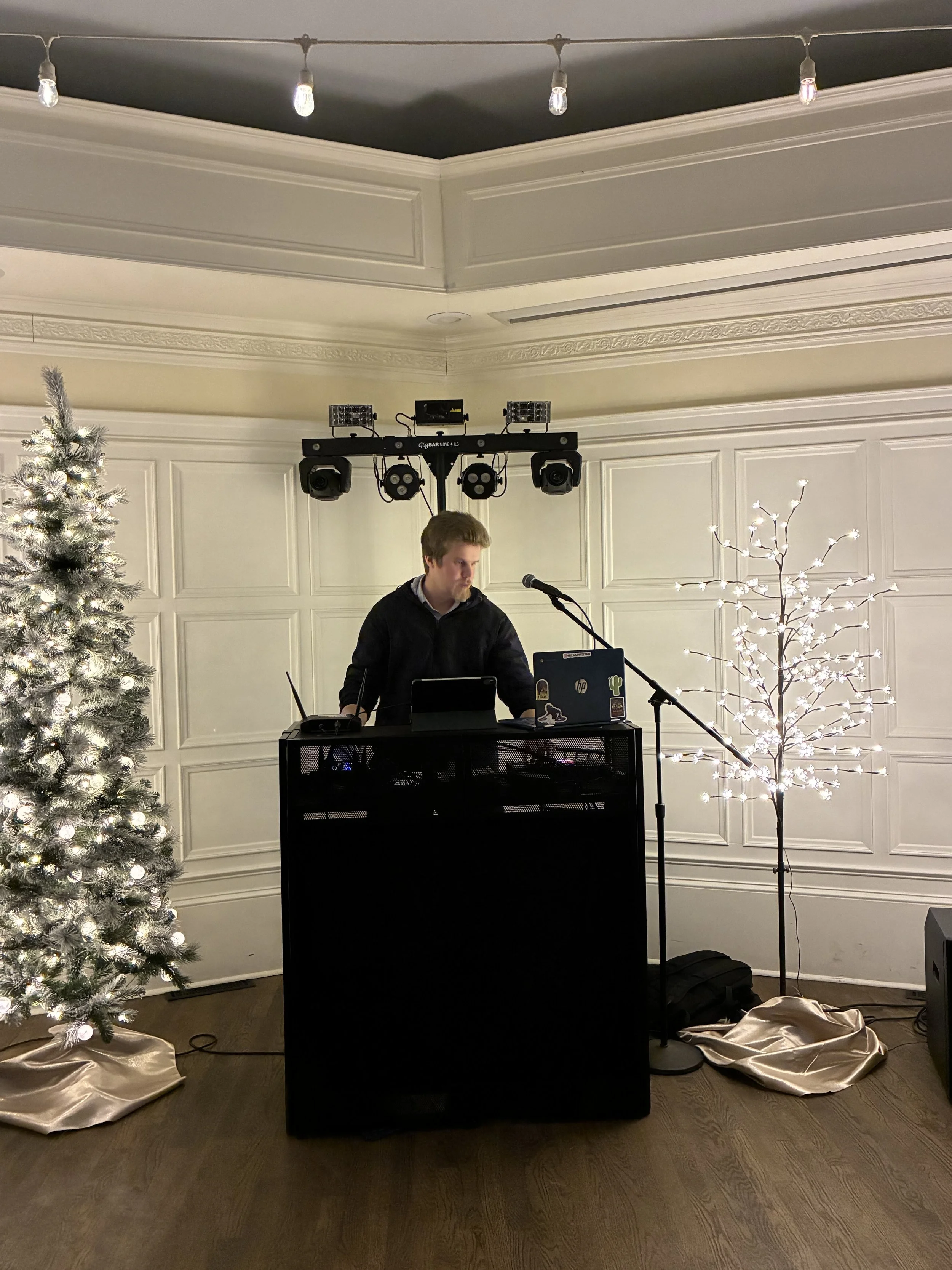 Premium DJ Noah Peterson, better known as DJ Northh, wearing a cream-colored textured polo shirt and black pants, standing on a winding path in a forested area during daylight.