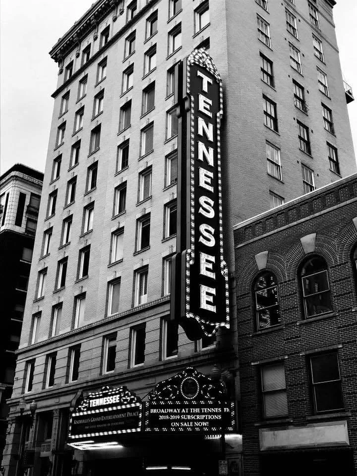 Indoor stage with a Premium DJ performing, elegant large glass windows, and surrounded by speakers and stage equipment.