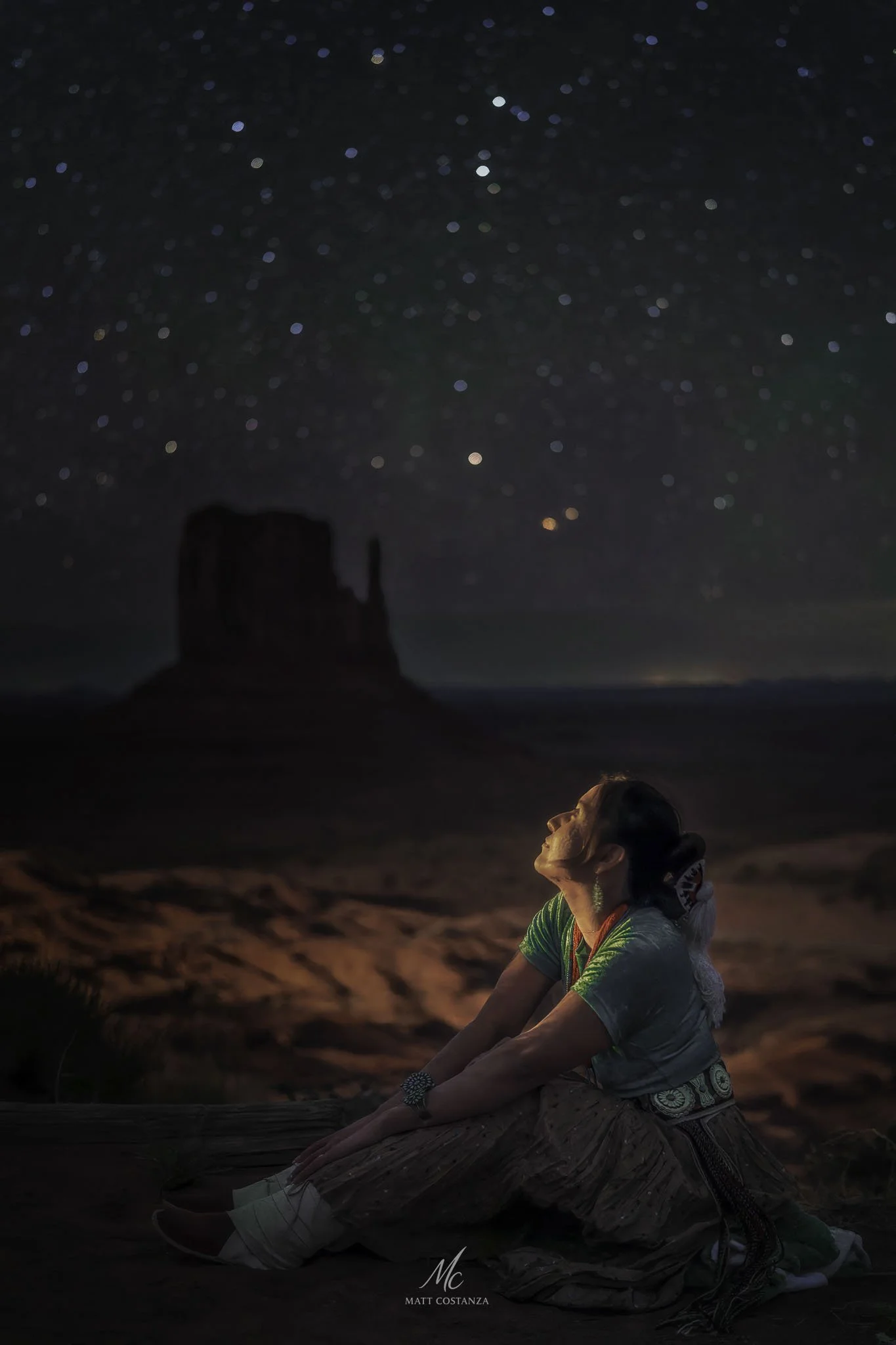 Navajo woman beneath a starry sky in Monument Valley, Arizona