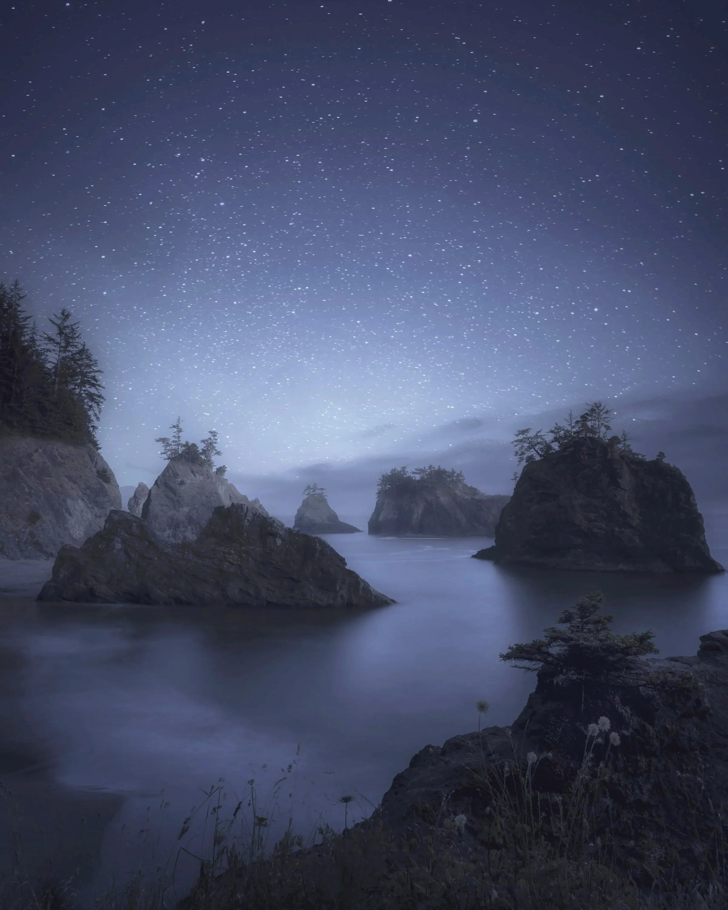 Star-filled night sky above sea stacks and calm ocean water at Secret Beach on the southern Oregon Coast.