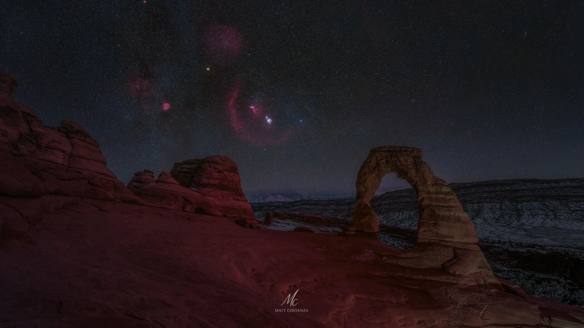 Delicate Arch under the Milky Way with Orion rising above the snow-dusted desert, Arches National Park, Utah