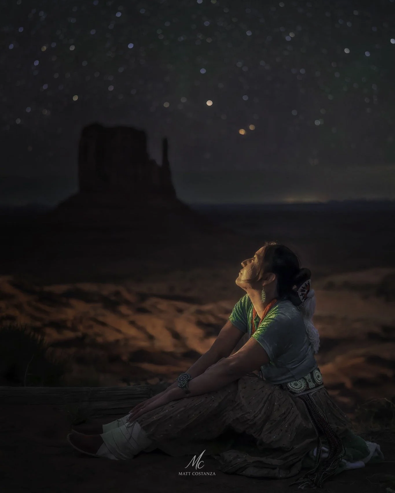 Navajo woman beneath a starry sky in Monument Valley, Arizona