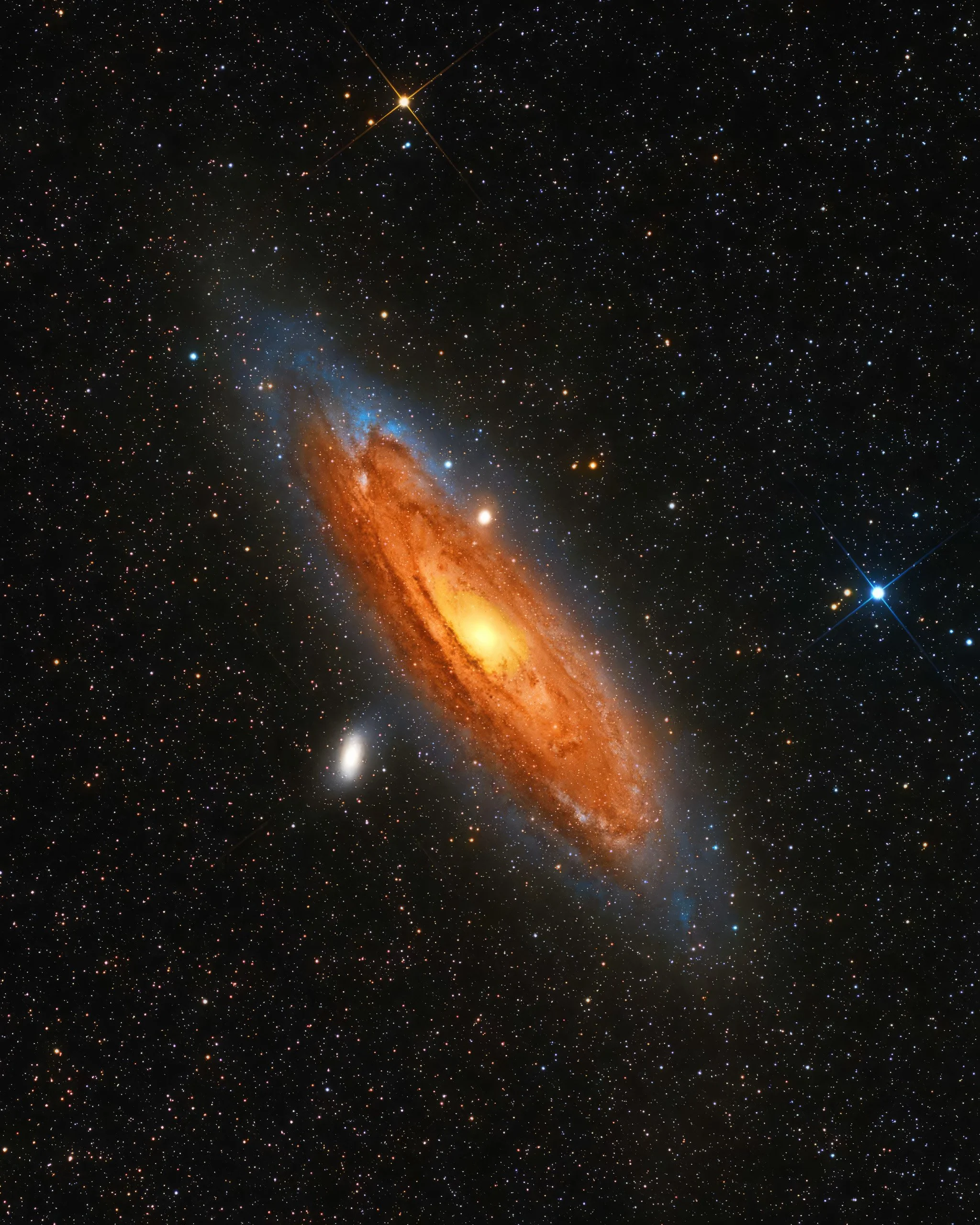 High-resolution astrophotograph of the Andromeda Galaxy (M31) showing a glowing orange galactic core and spiral arms against a star-filled night sky, captured by astrophotographer Matt Costanza.