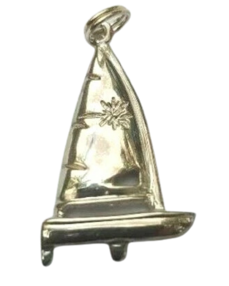 Silver sailboat-shaped pin with engraved details of a sail and a plant.