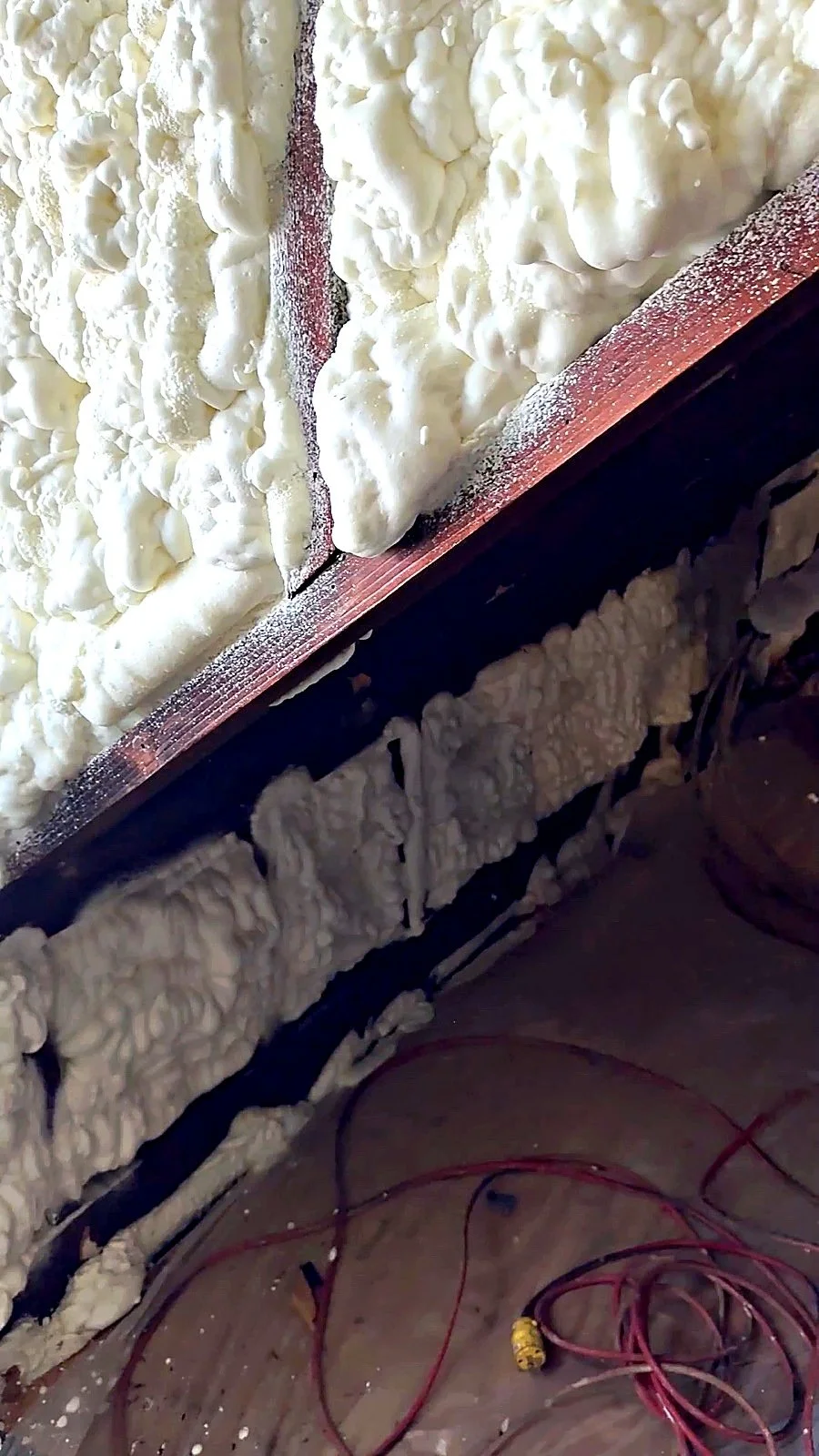 Closed-cell spray foam air sealing at a roof rafter bay on a Raimo Renovations job