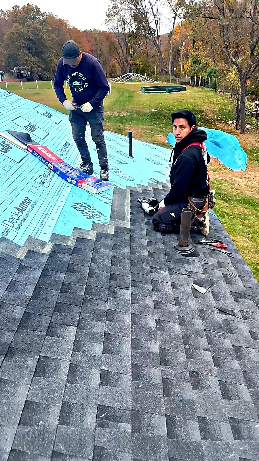 Raimo Renovations crew installing GAF Timberline architectural shingles over Deck-Armor underlayment on a residential roof