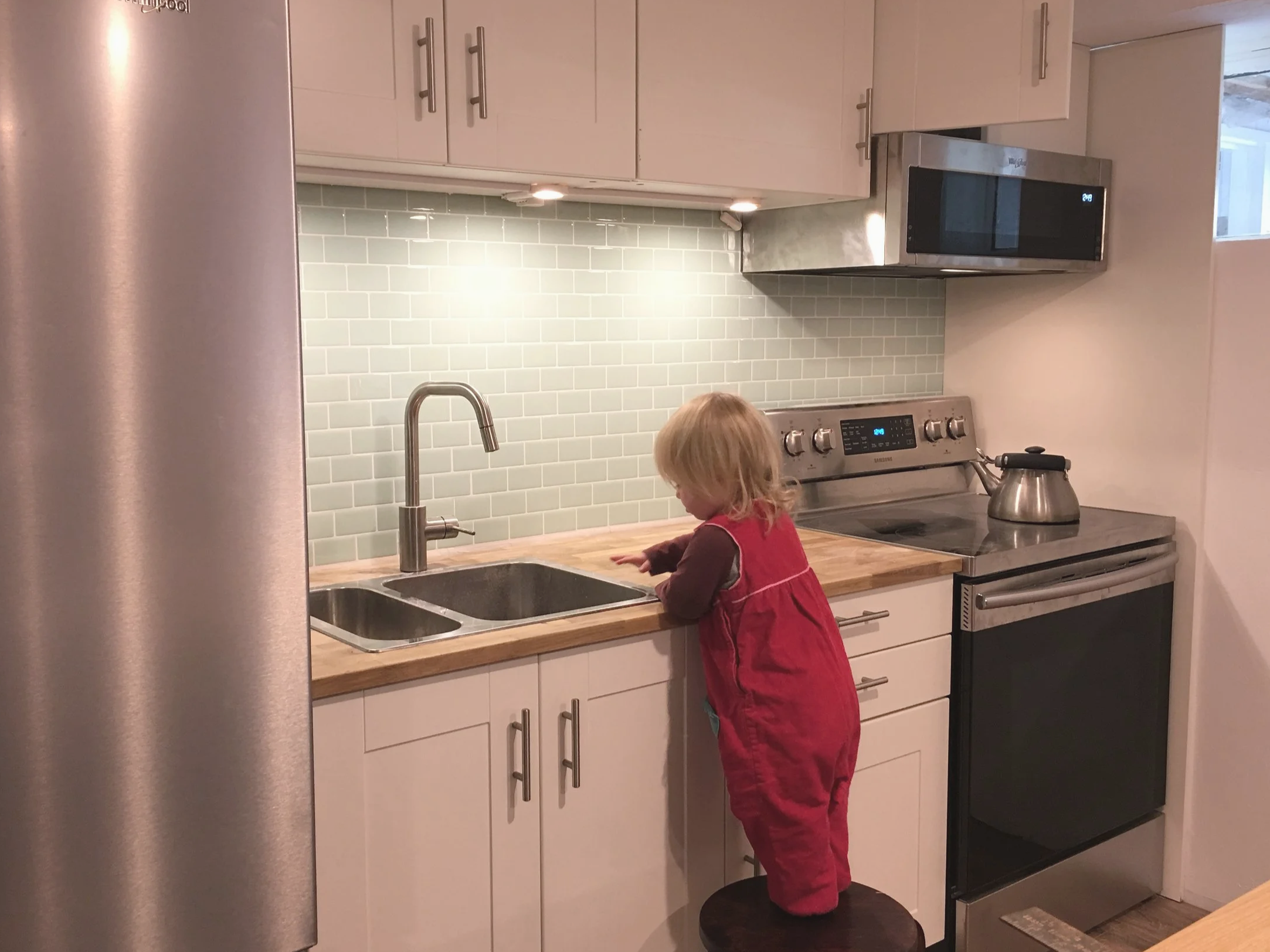 Simple and compact kitchen in a 1-bedroom ADU basement conversion.
