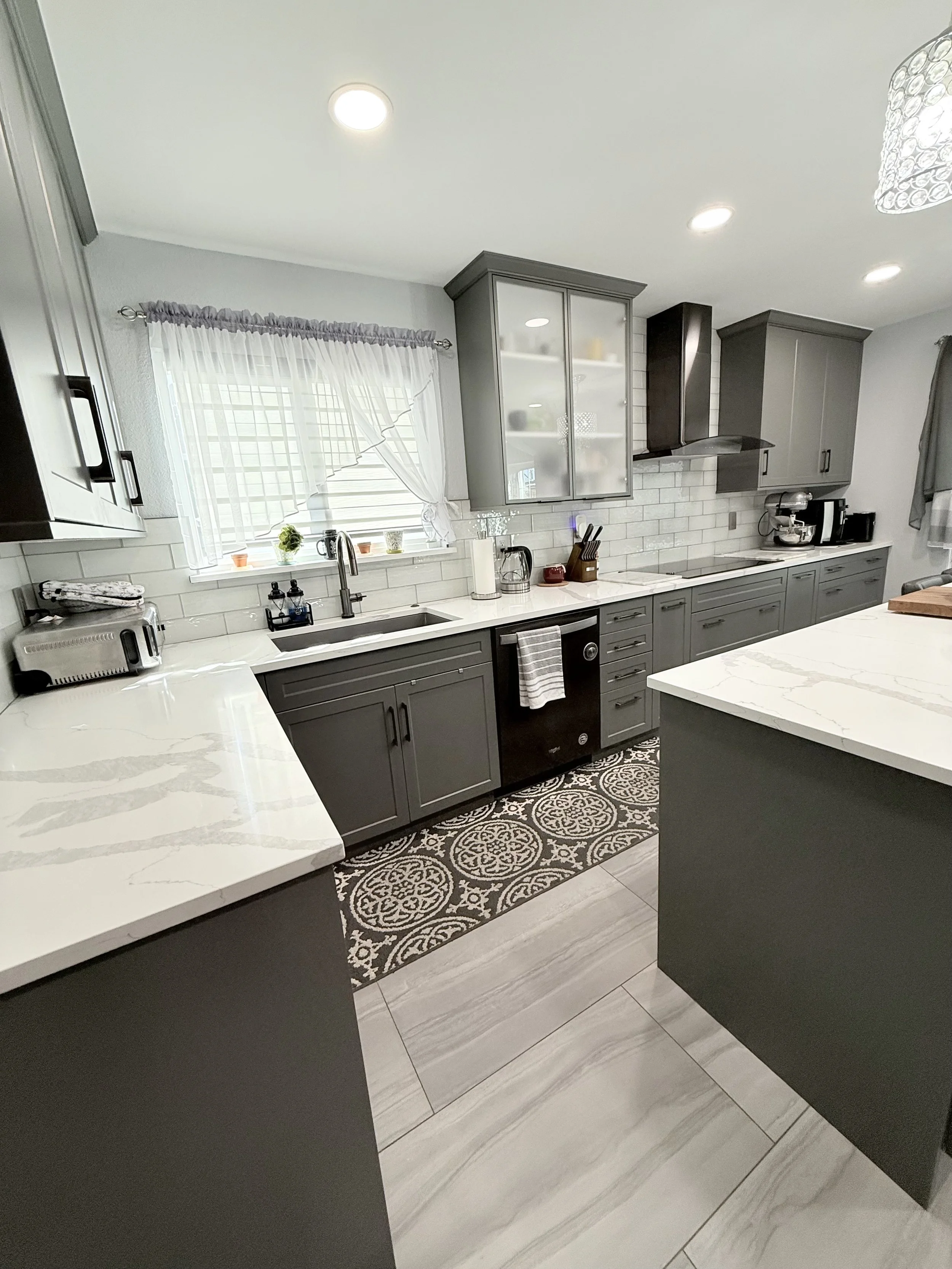 Gray kitchen cabinets with white and gray veined countertop design