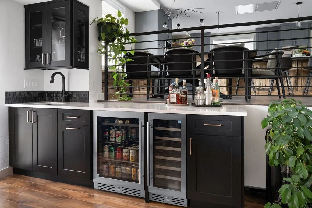 Custom home bar featuring dark Woodland cabinetry, beverage storage, and modern finishes designed for effortless entertaining.