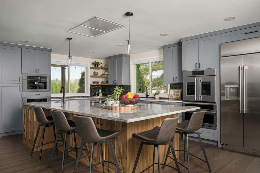 Contemporary kitchen renovation featuring custom cabinetry, oversized seating island, warm wood textures, and premium finishes throughout.