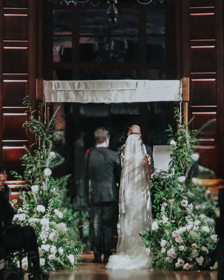 Wedding Chuppah inside a wedding venue with a bride and groom