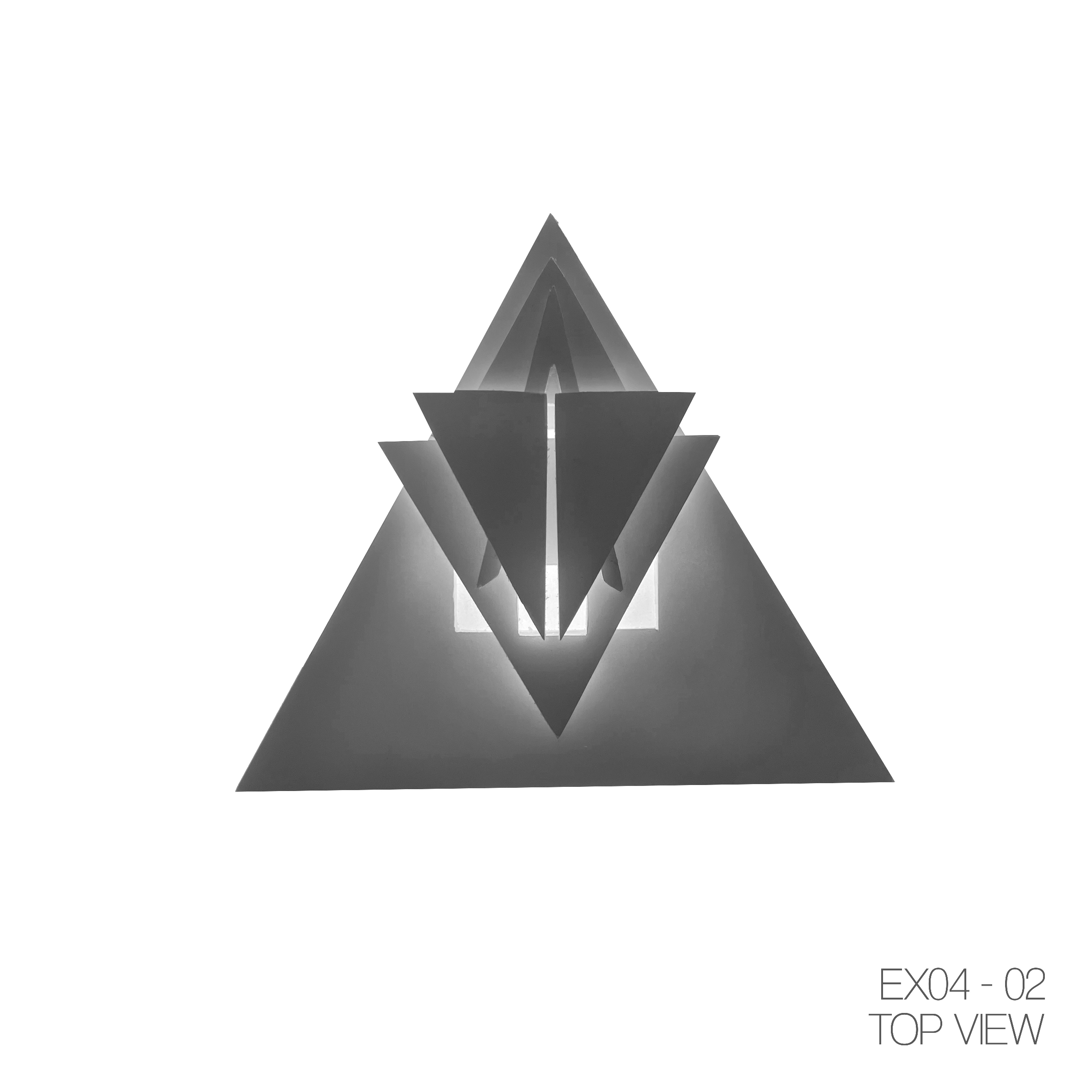 A geometric sculpture with multiple triangular shapes, illuminated from behind, appearing as a three-dimensional abstract art piece placed on a table with a pyramid shape surface. The image is black and white.