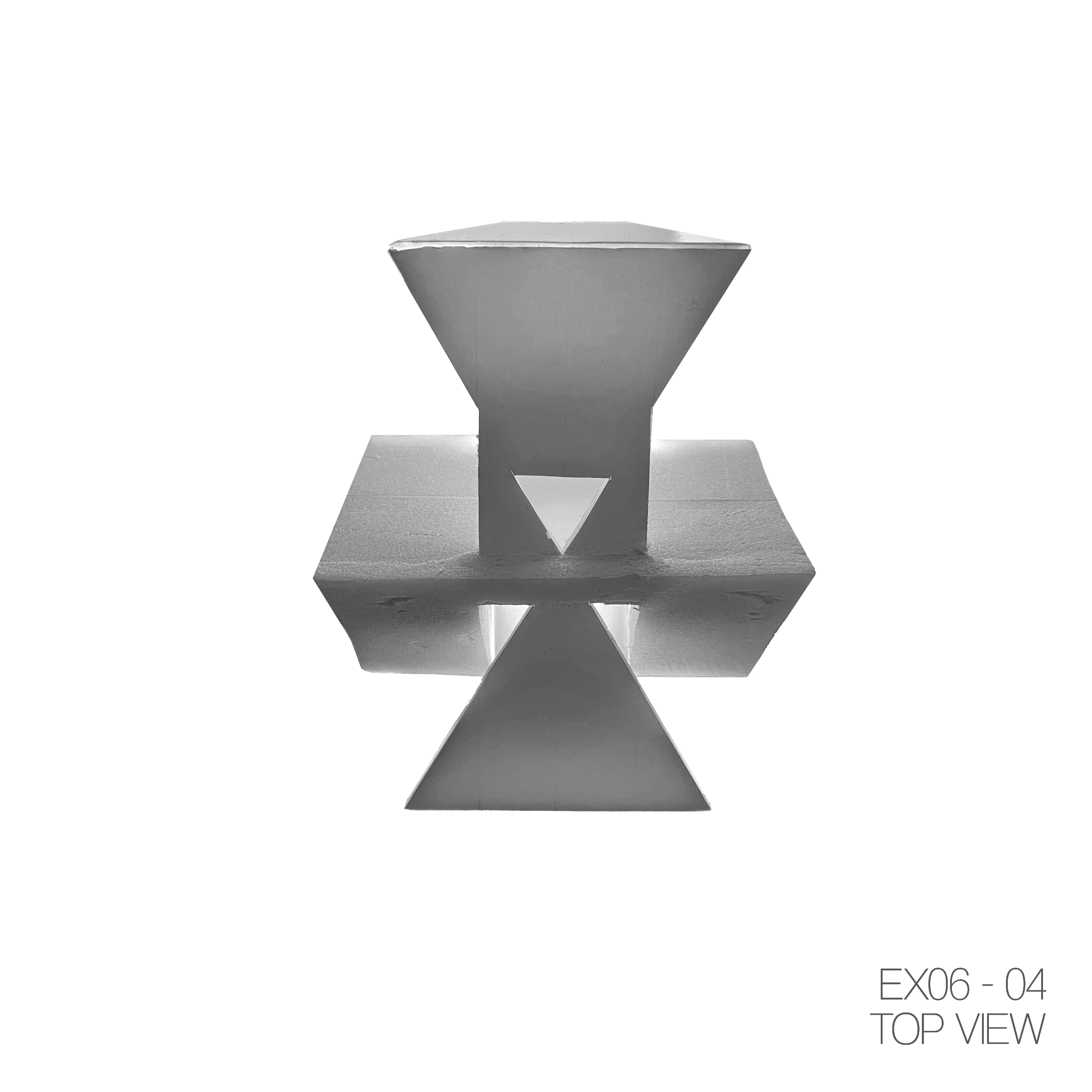 Black and white top view of a geometric sculpture made of a large cone, a cube with a triangular hole in the center, and two smaller cones, with a reflection underneath.