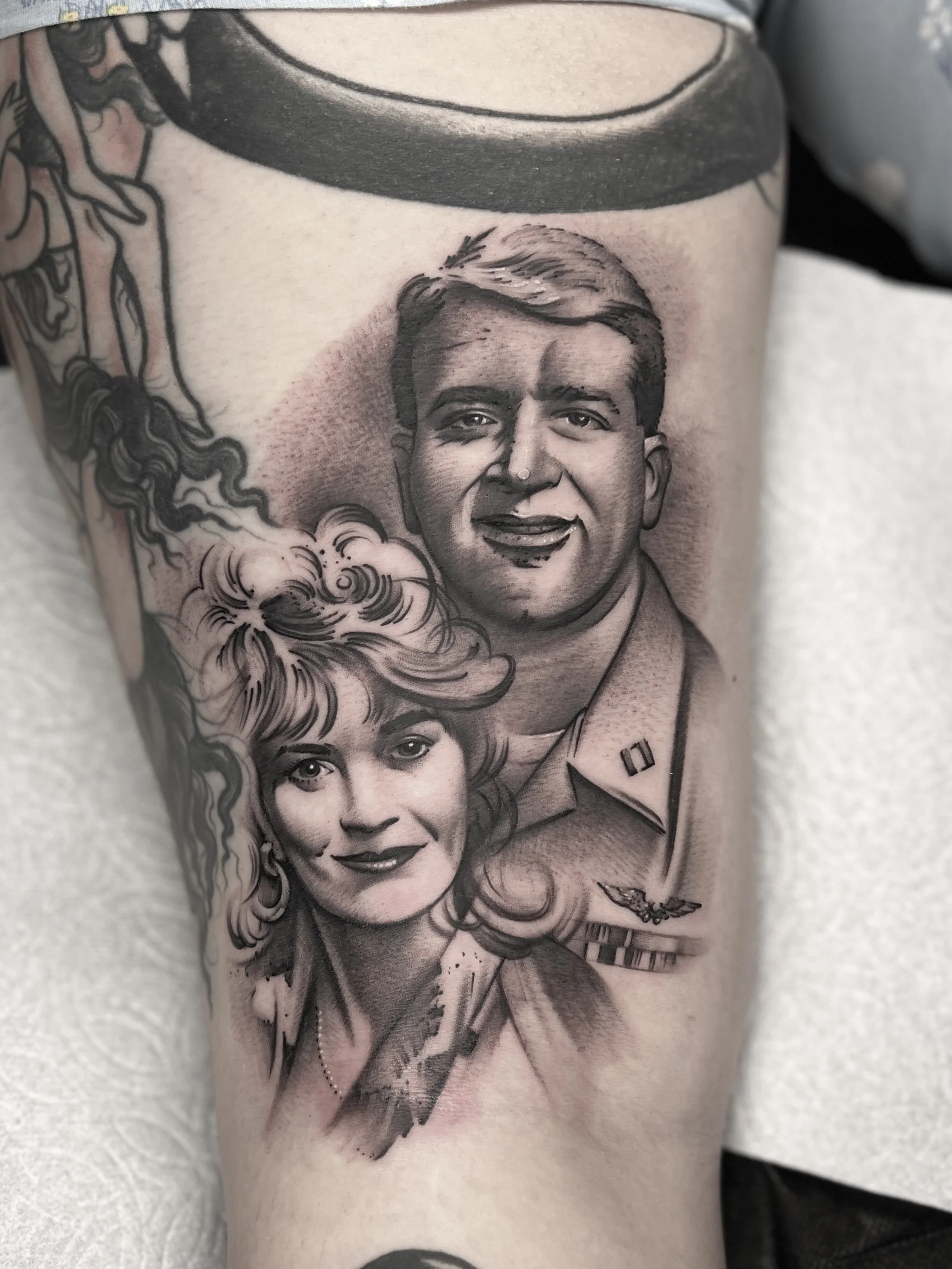 Black and grey double portrait tattoo of client’s parents. Award-winning piece from 2023.