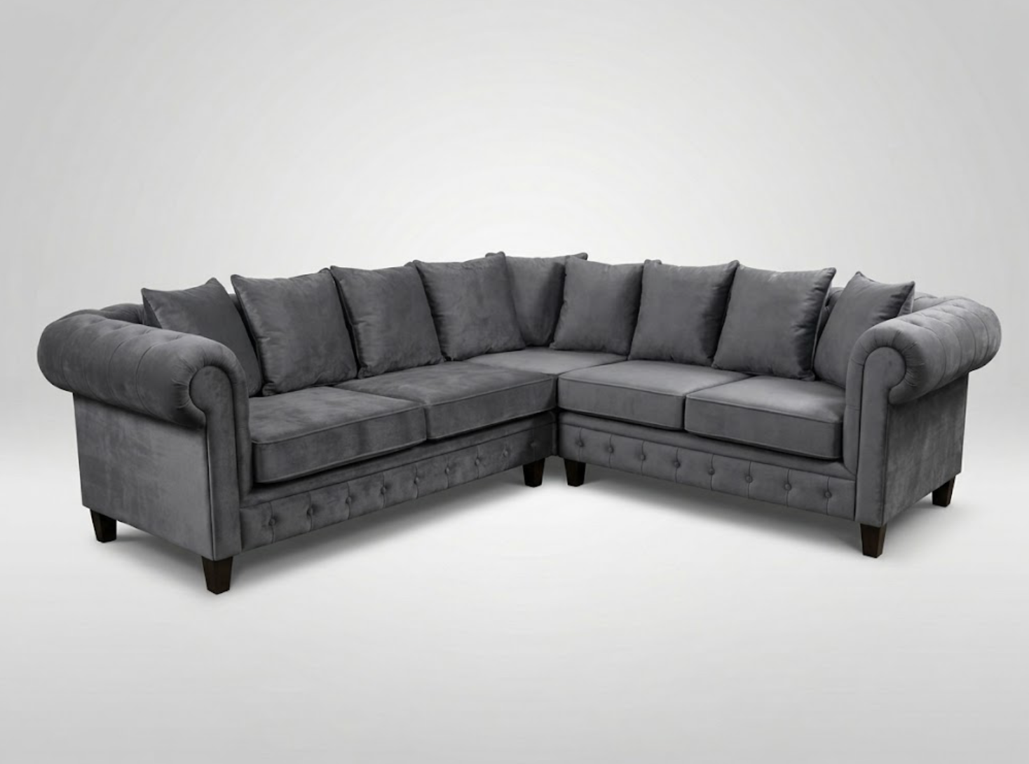 Gray sectional sofa with rolled arms and multiple gray throw pillows.