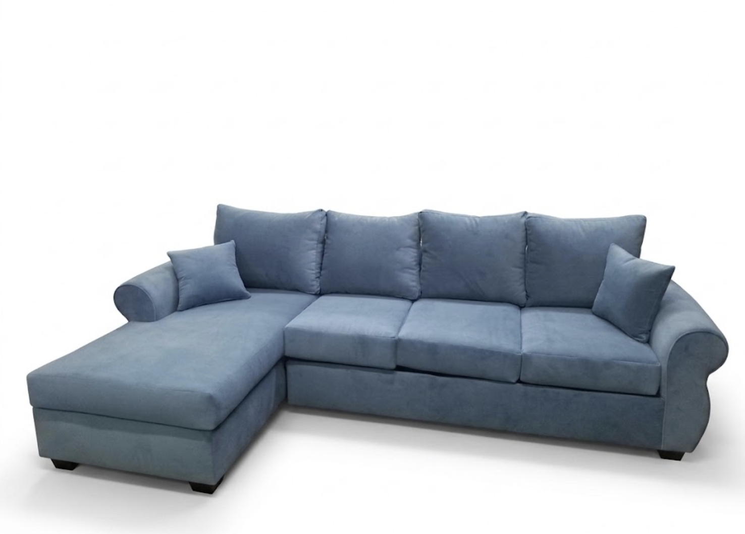 Blue sectional sofa with two small matching pillows on a white background.