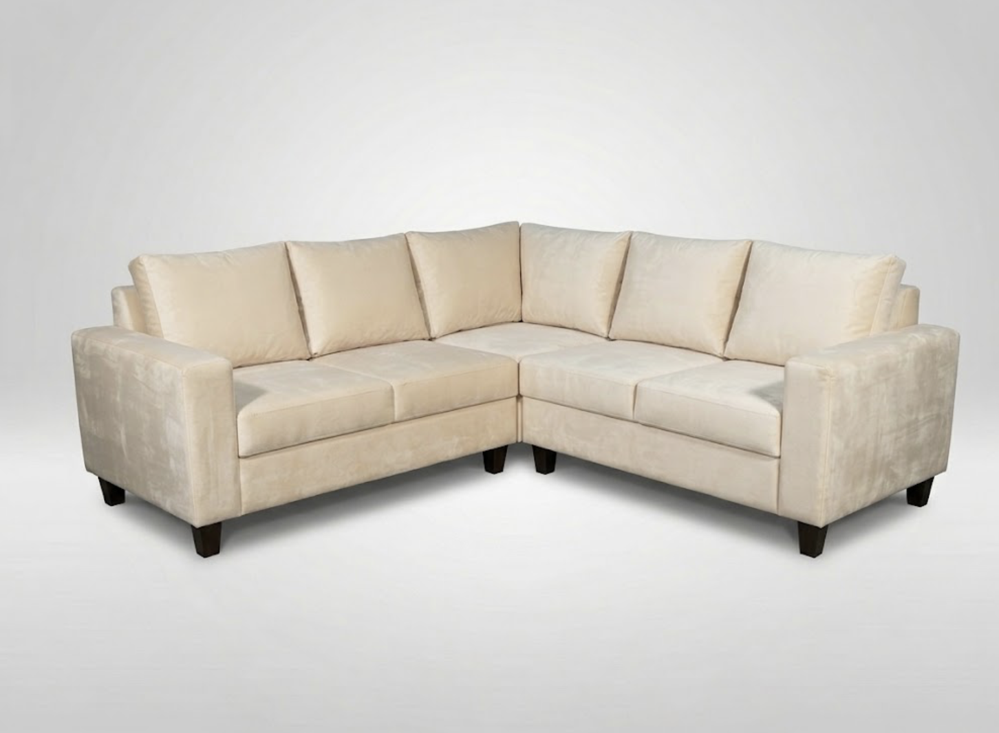 Beige L-shaped sectional sofa with six cushions on a plain white background.