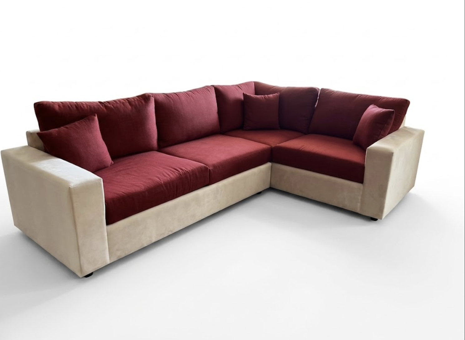 A sectional sofa with beige sides and burgundy cushions and pillows.