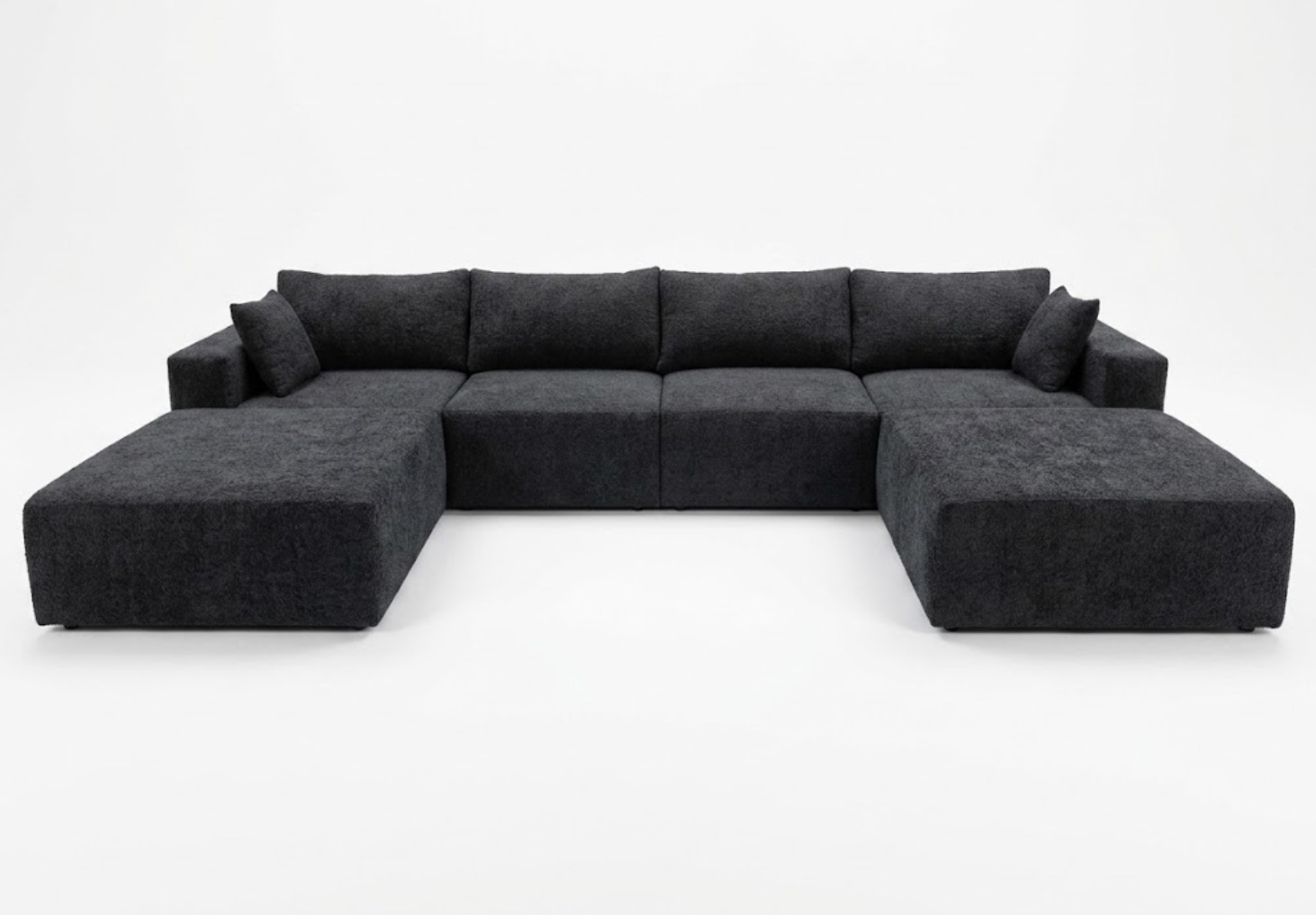 A large, L-shaped black sectional sofa with matching cushions, set against a plain white background.