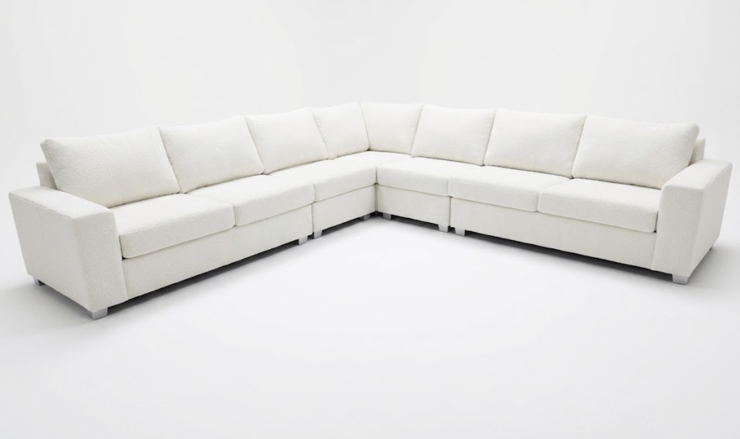 A large white sectional sofa with multiple cushions set against a plain white background.