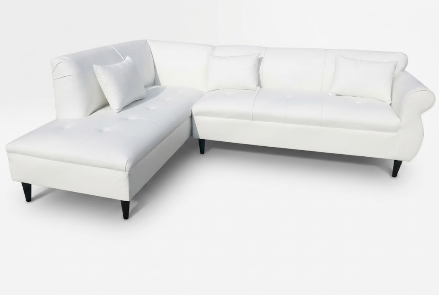 White sectional sofa with two matching throw pillows on a plain white background.