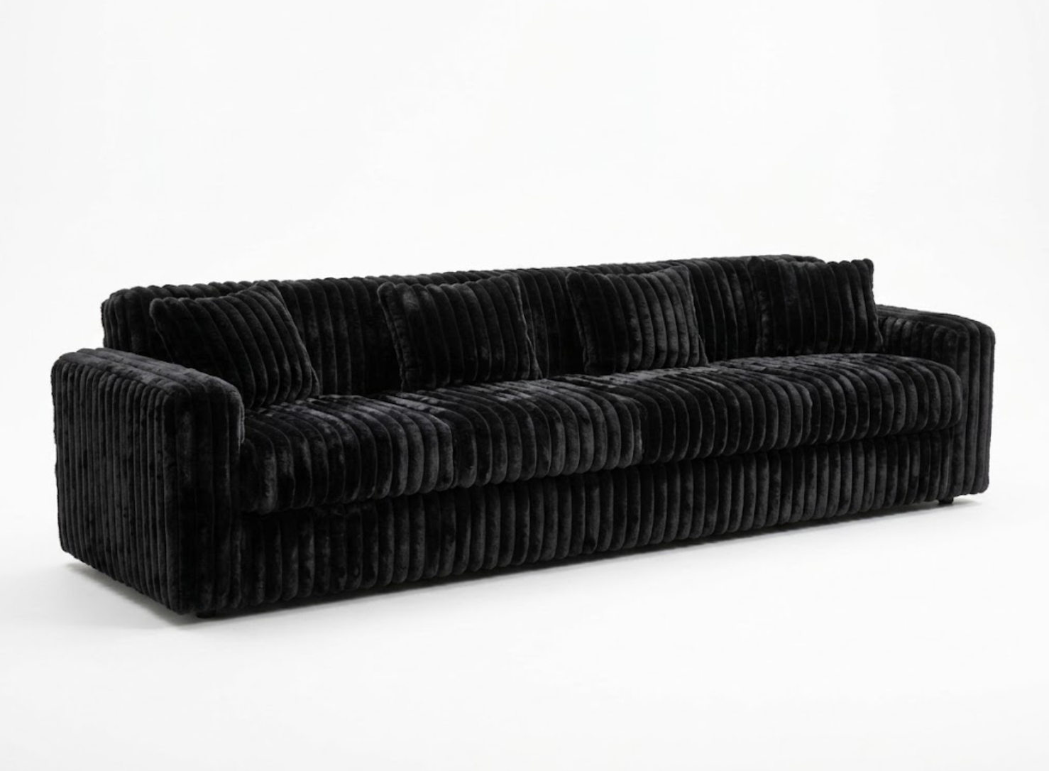 A long black velvet sofa with a ridged texture against a white background.