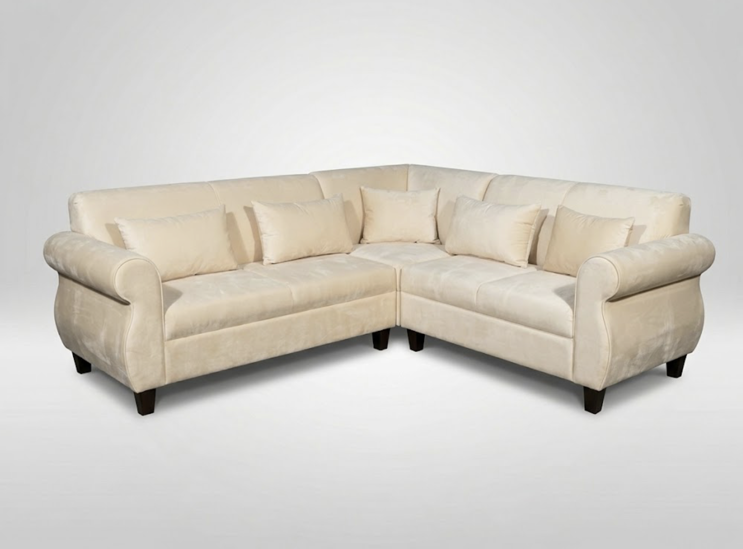 An L-shaped beige sectional sofa with rolled arms and matching cushions, set against a plain white background.