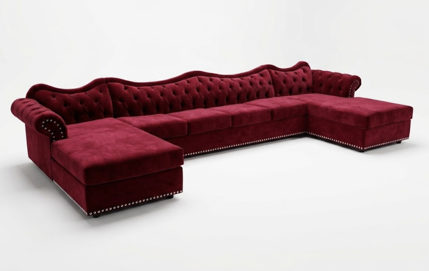 A large, red velvet, sectional sofa with tufted backrest and armrests, set against a plain white background.