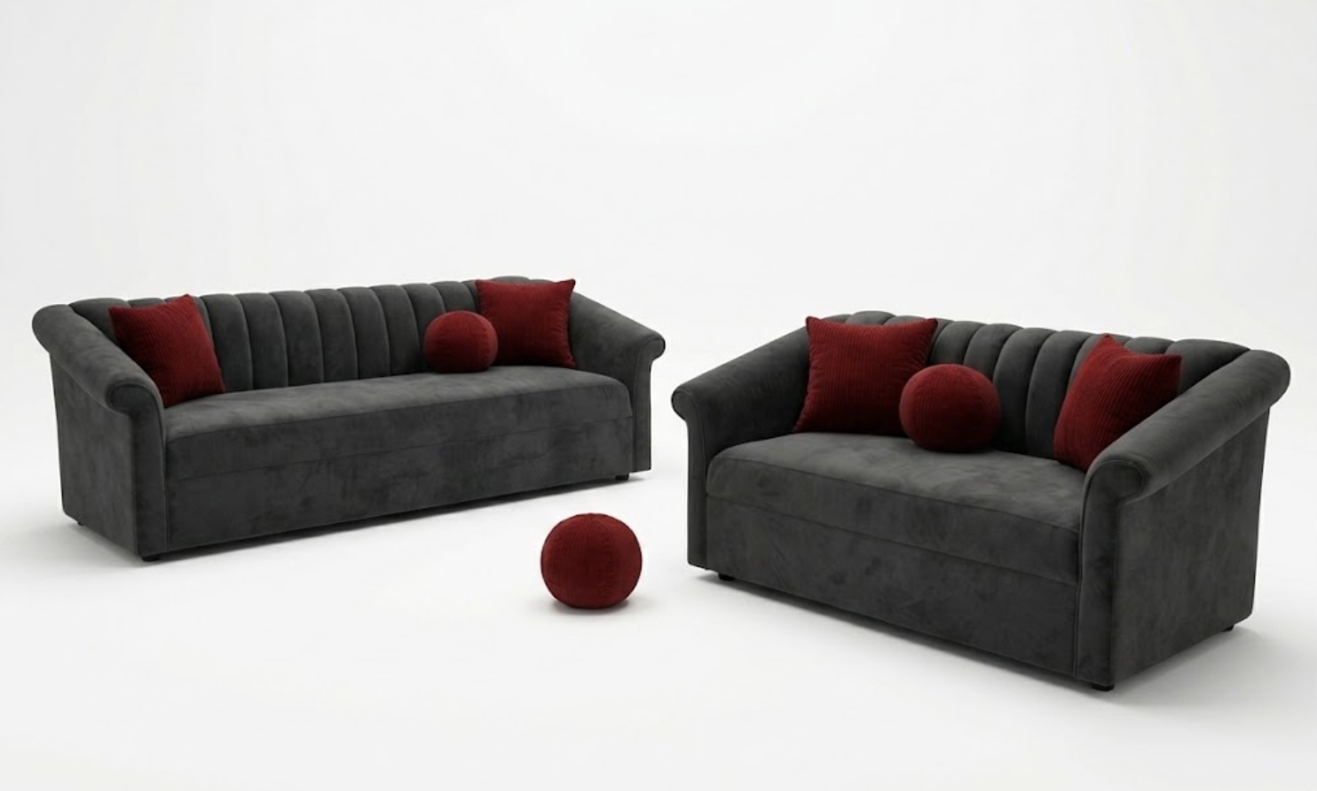 Two dark gray sofas with red pillows and round red cushions on a white background.