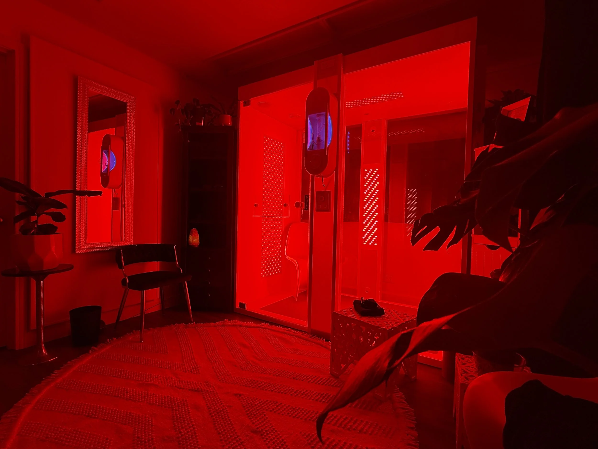 Neon red and pink heart-shaped light outlines layered in a pattern, creating a visual of concentric hearts.