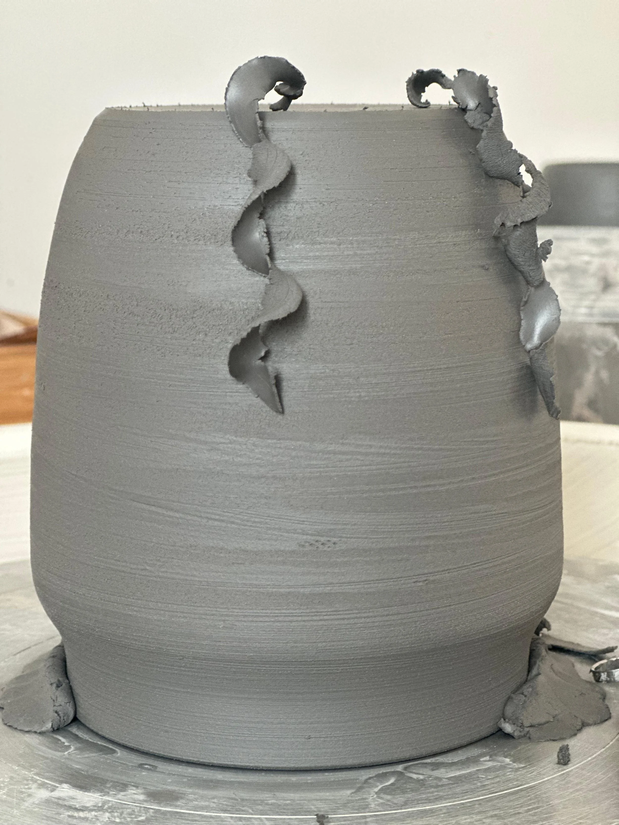Clay being shaped on the wheel