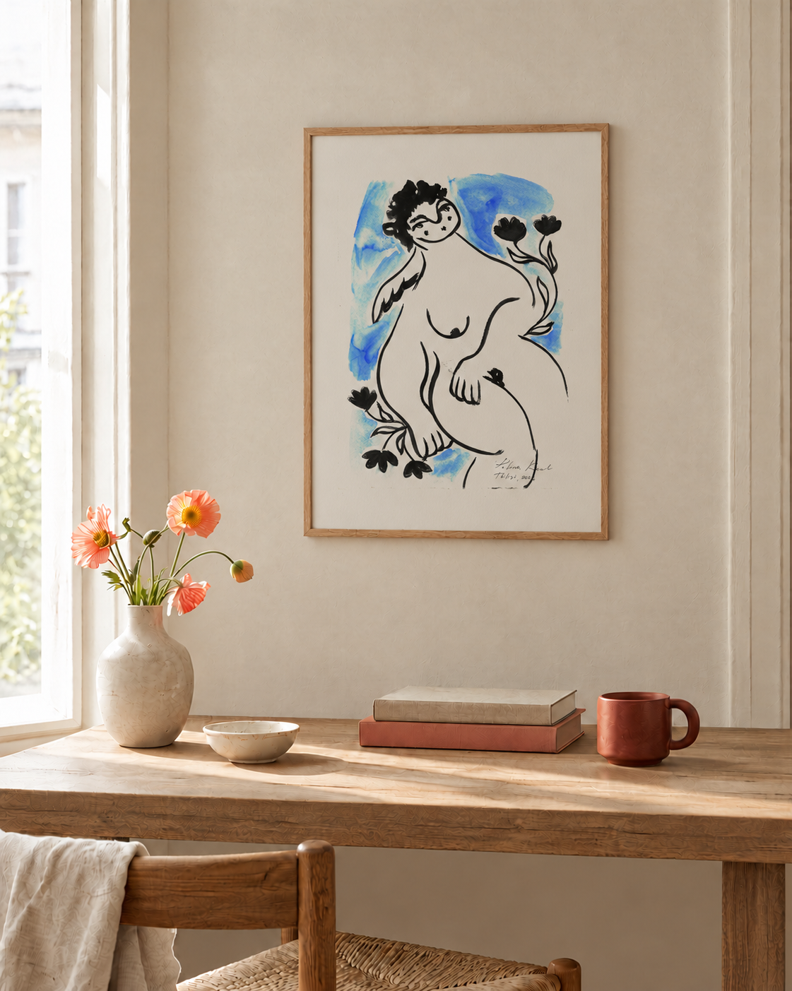 Framed print “Angel by the Seaside” on a wooden table with a mug and small decor in a warm, sunlit room