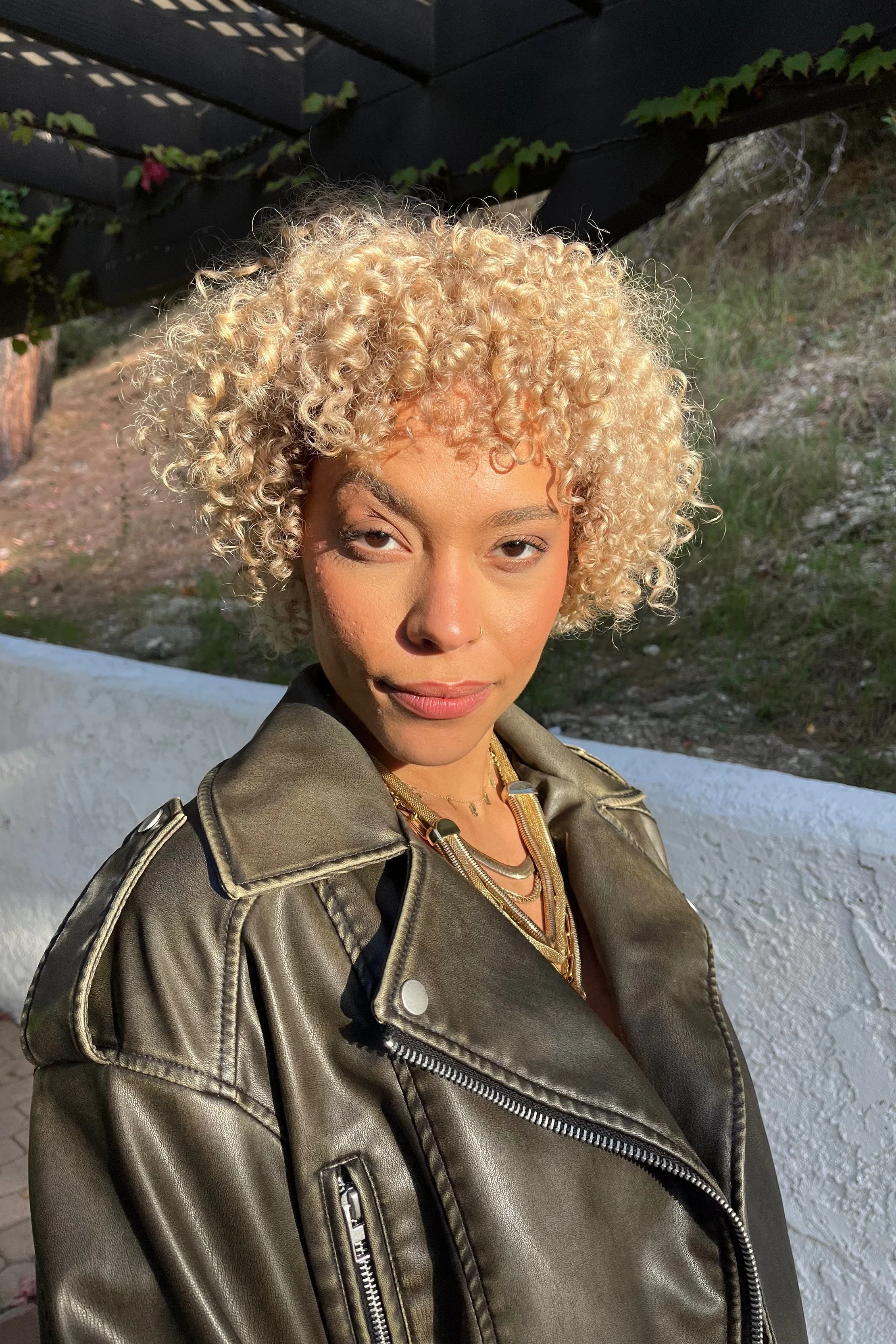 Short curly blonde hair with dimensional highlights at Alfa Jae Salon in Cary, NC