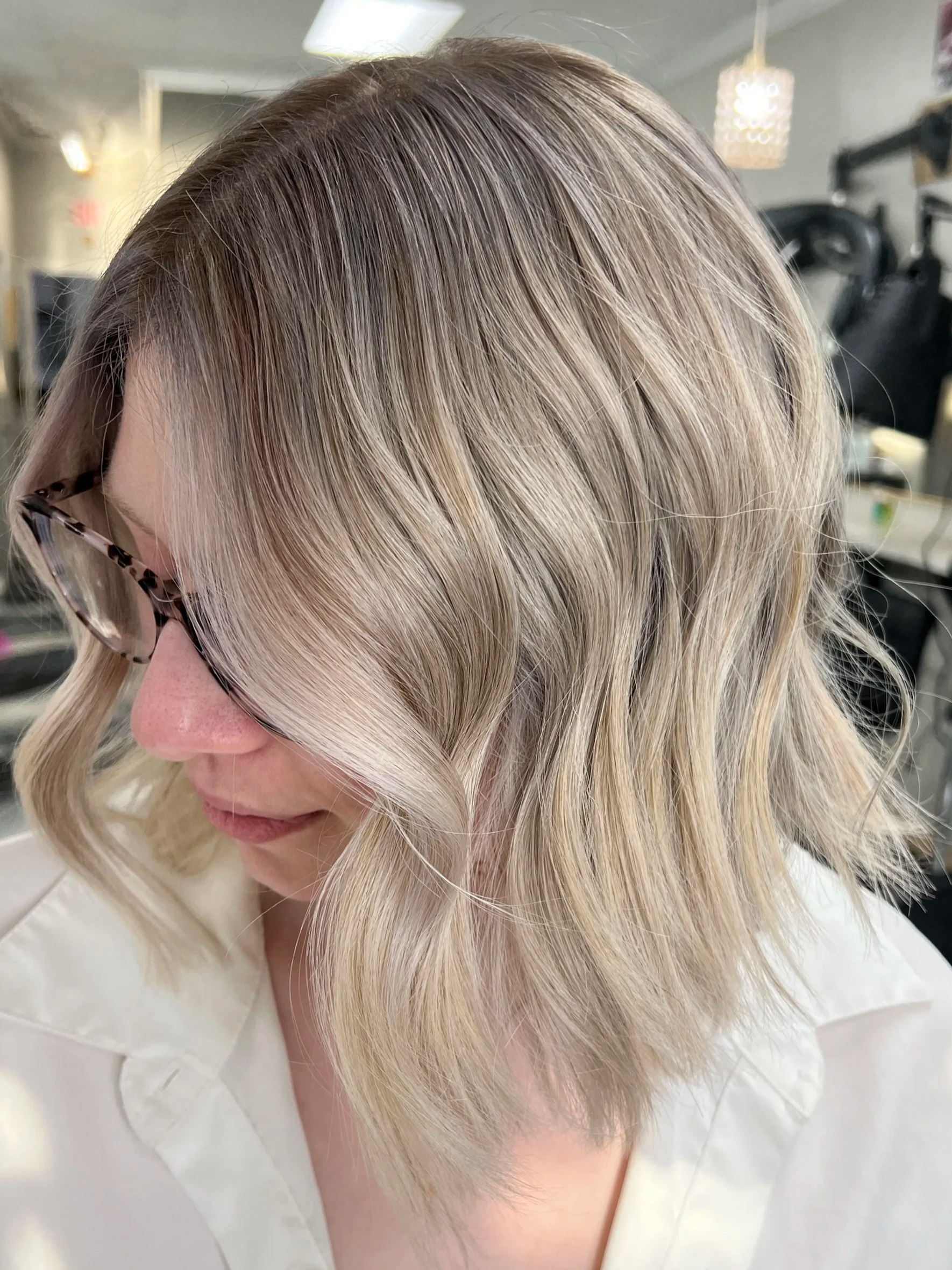 Dimensional blonde bob with bright face framing highlights at Alfa Jae Salon in Cary, NC