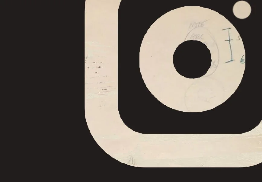 Close-up of a camera icon with a handwritten note on the inner circle and a small circle in the top right corner.