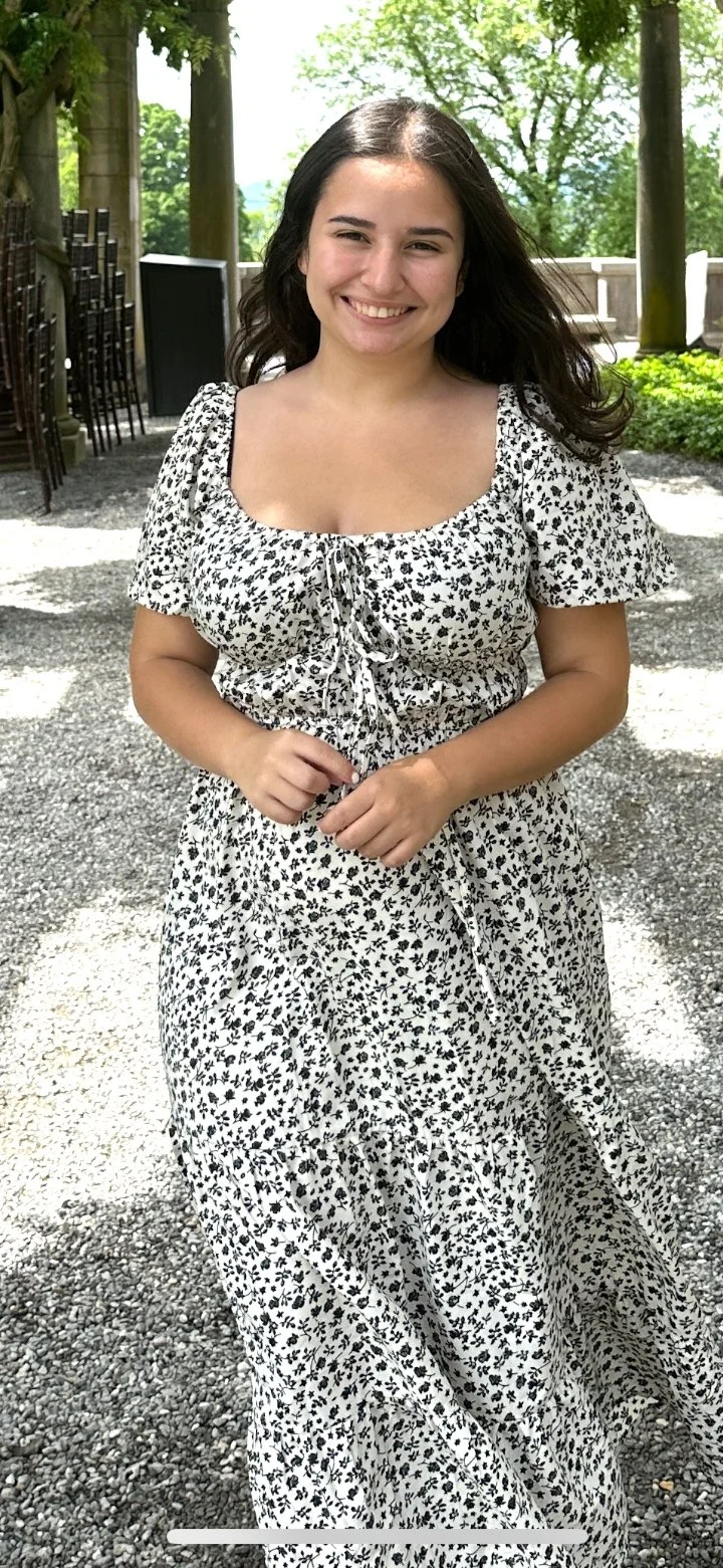 Gainesville Florida Based Birth Doula Angela Seminara stands smiling in a garden, excited to support families through pregnancy, birth, and postpartum.