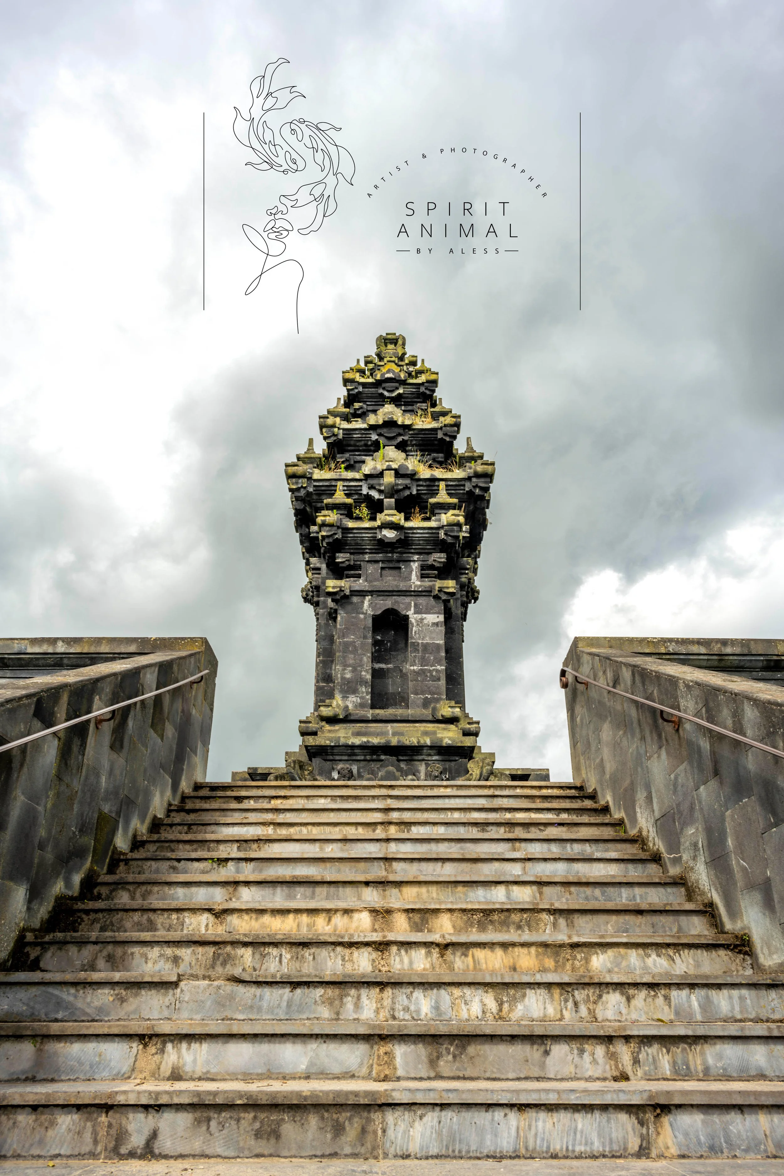 Steinerne Treppe führt zu einer kunstvoll gestalteten dunklen Tempel- oder Pagodenstruktur unter einem bewölkten Himmel, Fotografie von SPIRIT ANIMAL