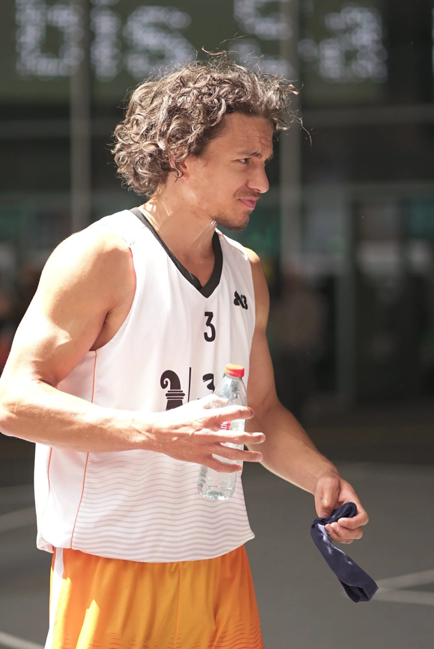 Mann in Sportkleidung mit Wasserflasche und einem Tuch in der Hand