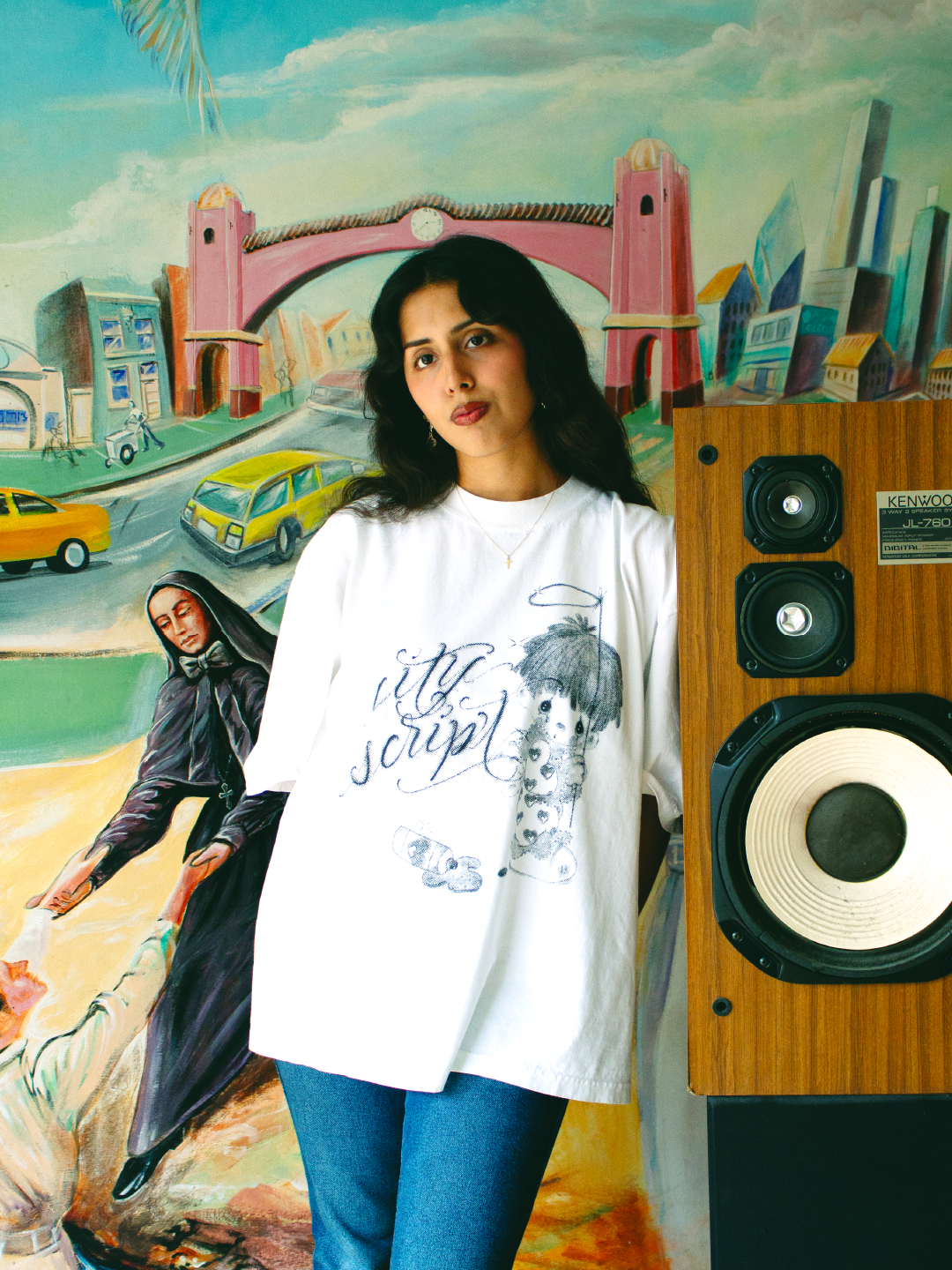 young woman wearing a tshirt of precious moments design of kid holding a halo with the words city script next to him