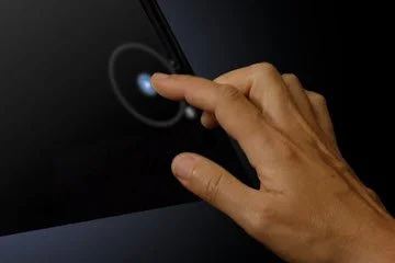 A hand touching a smartphone screen with a fingerprint scanner interface