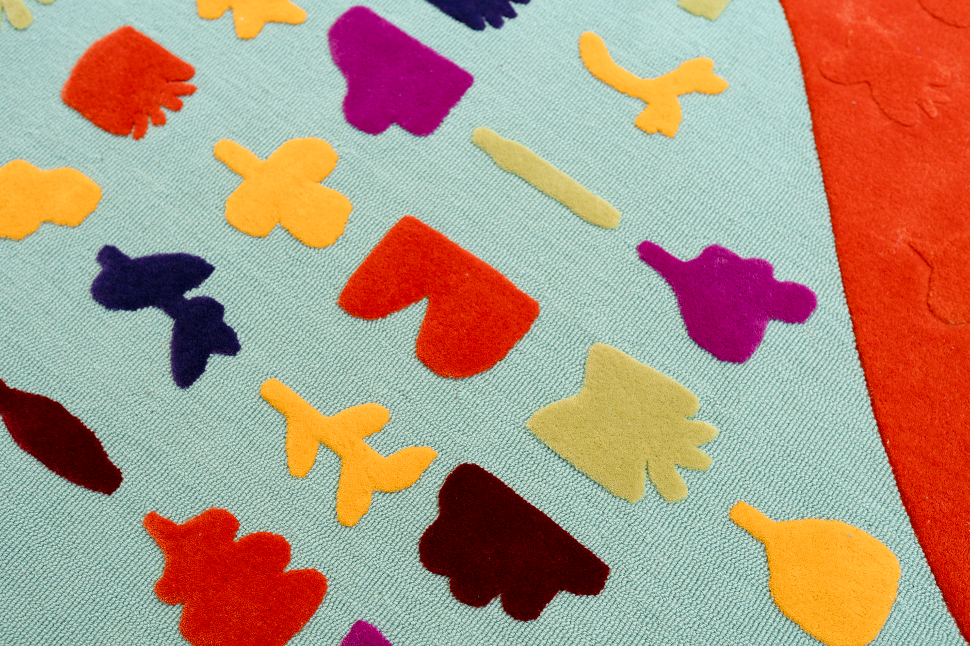 Colorful felt shapes of butterflies, ducks, and other insects arranged on a light blue fabric surface.
